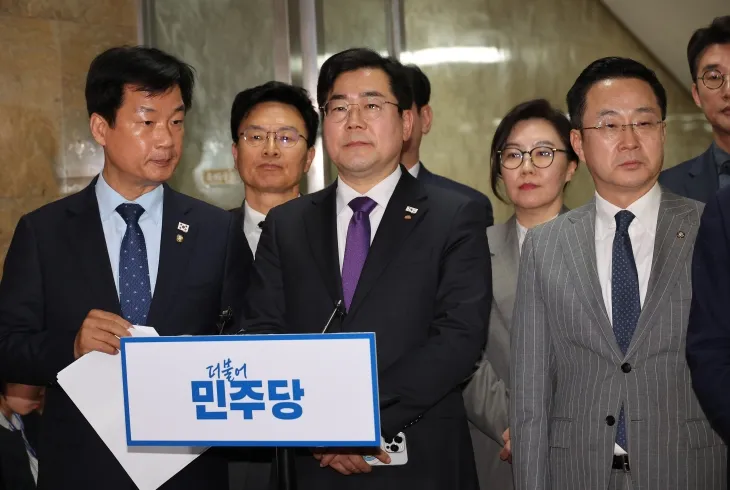 법원이 윤석열 대통령의 구속 취소 청구를 받아들인 7일 서울 여의도 국회에서 더불어민주당 박찬대(왼쪽에서 세 번째) 원내대표와 의원들이 긴급 의원총회 도중 잠시 나와 취재진의 질문을 받고 있다.  연합뉴스