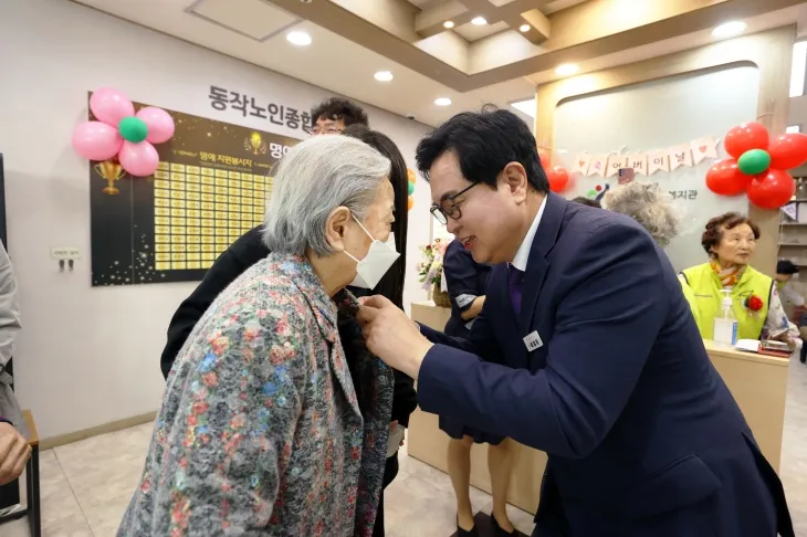 박일하(오른쪽) 서울 동작구청장이 지난해 5월 어버이날을 기념해 한 어르신에게 카네이션을 달아 드리고 있다. 동작구 제공