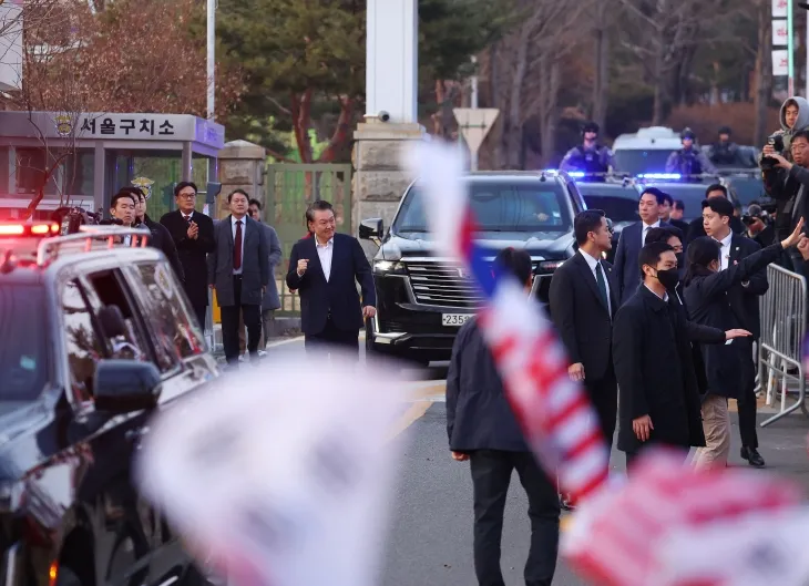 석방된 윤석열 대통령이 8일 경기도 의왕시 서울구치소를 나서며 차에서 내려 지지자들을 향해 주먹을 쥐어보이고 있다. 2025.3.8 연합뉴스