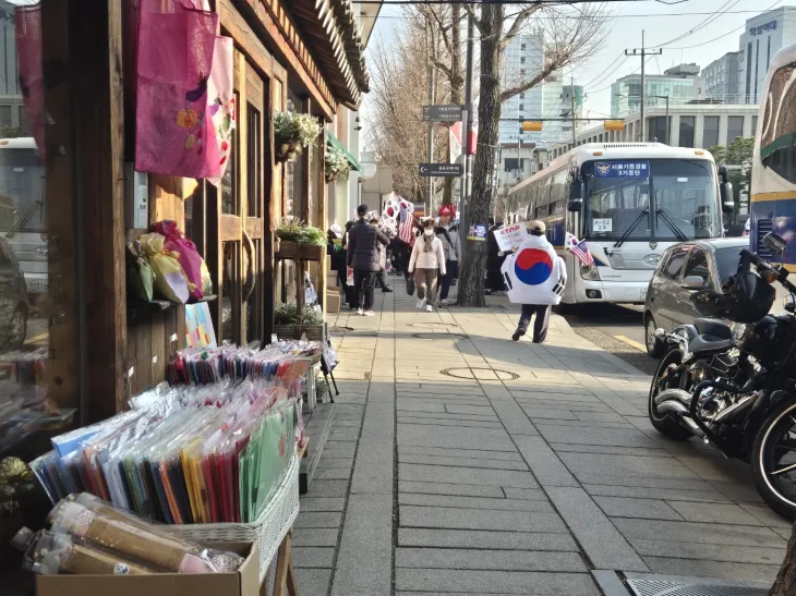 종로구청 가로정비과는 전날 헌재를 둘러싸고 집회 인원이 주로 모이는 도로 인근 상가들에 적치물 철수 협조를 요청했다. 사진은 헌재 인근에서 집회가 계속되는 가운데 인근 소품샵 앞에 가판대가 나와있는 모습. 김우진 기자