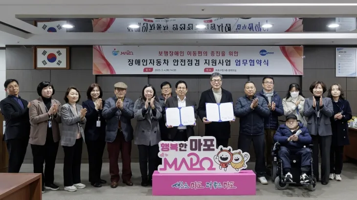 박강수(왼쪽 일곱번째) 서울 마포구청장이 장애인 자동차 안전점검을 위한 업무협약식을 맺고 기념 사진을 찍고 있다. 마포구 제공