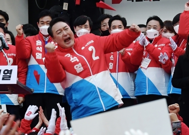 윤석열 대통령이 2022년 대선 운동 기간 지지자들의 환호에 특유의 어퍼컷 세리머니로 화답하는 모습. 연합뉴스