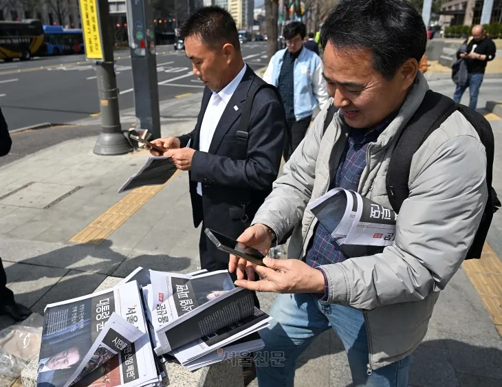 윤석열 대통령이 파면된 4일 오후 서울 중구 시청역 인근에서 시민들이 윤 대통령 파면 관련 서울신문 호외를 가져가고 있다. 2025.4.4 오장환 기자