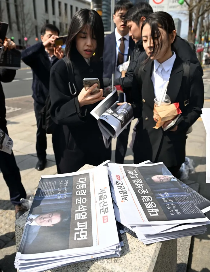 윤석열 대통령이 파면된 4일 오후 서울 중구 시청역 인근에서 시민들이 윤 대통령 파면 관련 서울신문 호외를 가져가고 있다. 2025.4.4 오장환 기자
