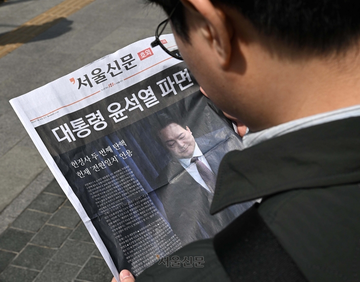 윤석열 대통령이 파면된 4일 오후 서울 중구 시청역 인근에서 시민들이 윤 대통령 파면 관련 서울신문 호외를 읽고 있다. 오장환 기자
