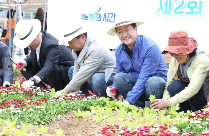 김진경 의장이 행사 직후 화단에 상추 모종을 직접 심고 있다.