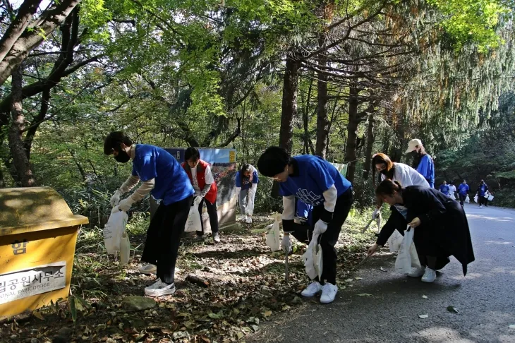광주신세계 임직원들이 ‘무등산 플로깅’에 참어해 등산을 하며 쓰레기를 줍고 있다.