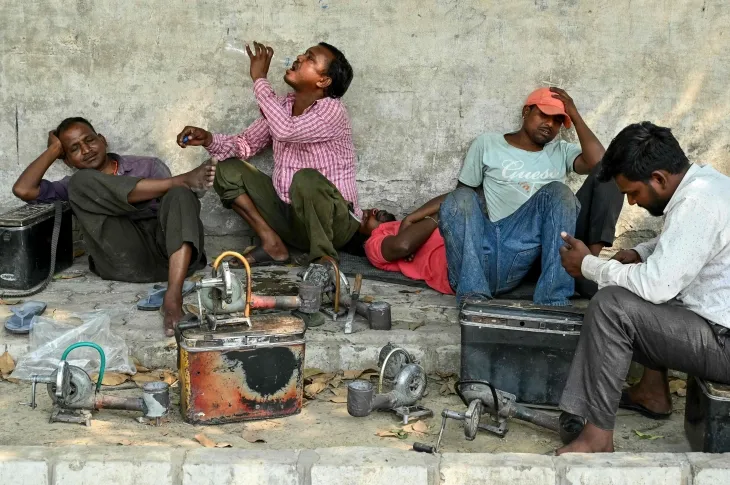 2025년 4월 15일 더운 여름날 인도 암리차르의 길가에서 기계공들이 나무 아래에서 물을 마시며 휴식을 취하고 있다. AFP 연합뉴스