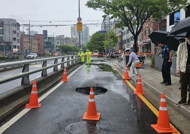 22일 서울 종로구 창신동에서 지름 1m 크기의 땅 꺼짐이 발생해 경찰이 인근 도로의 통행을 통제하고 있다. 연합뉴스