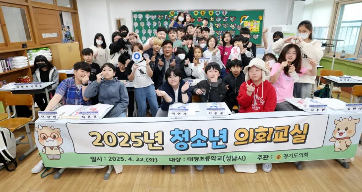 최만식 의원이  ‘2025년 청소년 의회교실’에 참여한 성남 태평초등학교 6학년 학생들과 손하트를 그리며 기념촬영을 하고 있다.