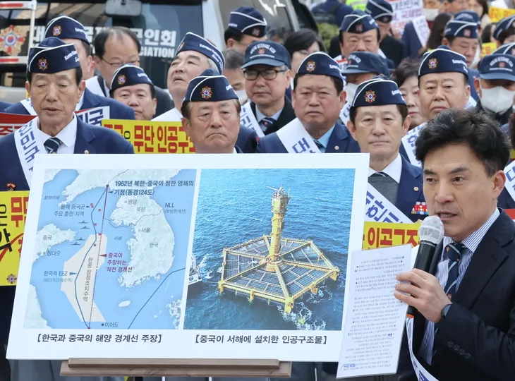 지난 3월31일 서울 중구 서울중앙우체국 앞에서 열린 ‘서해 무단 설치 중국 인공구조물 철거 촉구’ 집회에서 한 참석자가 구조물을 설명하고 있다. 연합뉴스