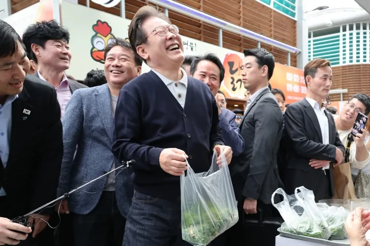 산나물 파는 노인과 대화하며 활짝 웃는 이재명 후보