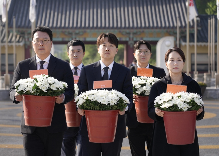 이준석(가운데) 개혁신당 대선 후보가 4일 국화꽃을 든 채 광주 북구 국립 5·18민주묘지에 들어서고 있다. 개혁신당 제공