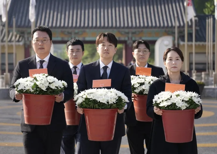 이준석(가운데) 개혁신당 대선 후보가 4일 국화꽃을 든 채 광주 북구 국립 5·18민주묘지에 들어서고 있다. 개혁신당 제공