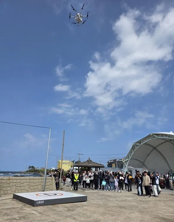제주도에서 올해 첫 드론배송서비스가 시작된 지난 10일 제주시 한림읍 비양도에서 3.5㎞ 떨어진 금능해변에서 출발한 쿠키 등을 드론으로 배송받고 있다. 제주도 제공