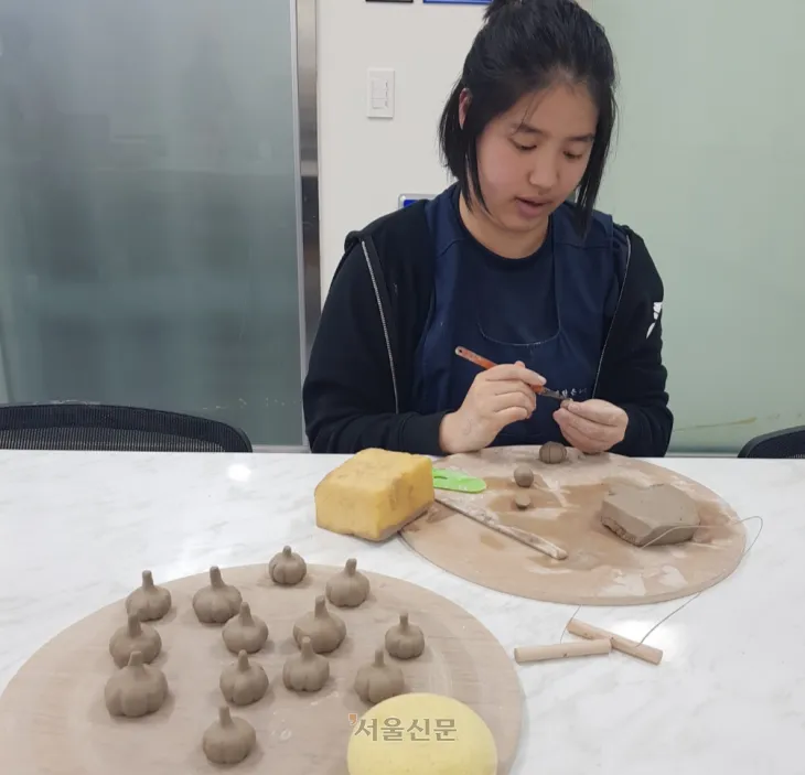 미대생 김란은씨가 대정읍 특산물인 마늘 모양의 도자기를 만들고 있다.