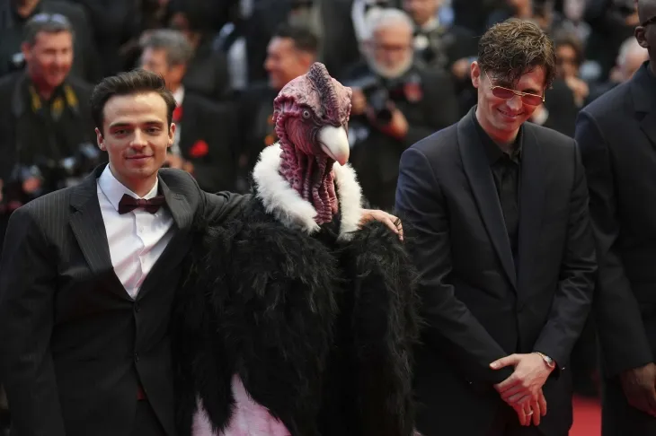 17일(현지시간) 프랑스 칸에서 열린 제78회 칸 국제영화제 ‘Die My Love ’ 시사회에서 콘도르 복장을 한 참석자와 다큐멘터리 ‘아이 러브 페루’(I Love Peru) 감독 라파엘 크나르(오른쪽), 위고 다비드가 레드카펫을 밟고 있다. AP 뉴시스