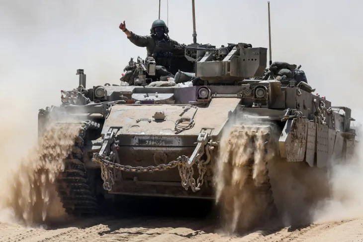 20일(현지시간) 팔레스타인 가자지구와 이스라엘 남부 국경에서 이스라엘 군인이 군용차 위에서 손짓하고 있다. 2025.5.20 가자 AFP 연합뉴스