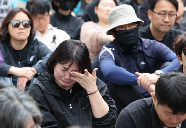 24일 서울 경복궁 영추문 앞에서 열린 전국교직원노동조합 창립 36주년 전국교사결의대회에서 한 참가자가 최근 제주도의 한 중학교에서 교사가 사망한 사건과 관련한 발언을 듣다 눈물을 흘리고 있다. 연합뉴스