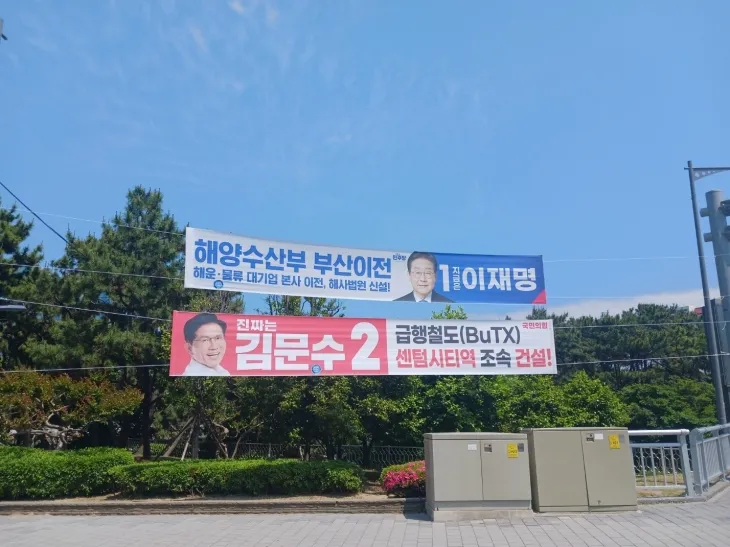 26일 부산 해운대구의 한 거리에 양당의 대선 후보가 제시한 공약들이 담긴 현수막이 걸려있다. 이재명 더불어민주당 후보는 해양수산부의 부산 이전을 공약했고, 김문수 국민의힘 후보는 부산형 급행철도(BuTX)의 센텀시티역 조속 건설을 약속했다. 부산 김서호 기자
