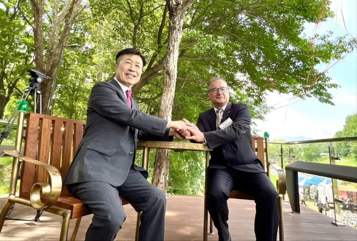 전성수(왼쪽) 서울 서초구청장과 이반 얀차레크 주한 체코대사가 양재천 하벨 벤치에 앉아 손을 맞잡고 있다. 서초구 제공