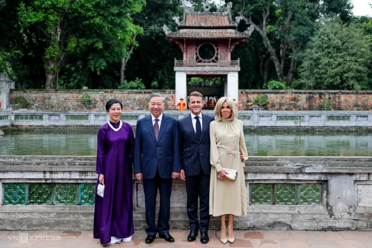 마크롱 대통령 부부가 27일 베트남 수도 하노이에서  또 럼 베트남 서기장 부부와 기념사진을 찍고 있다. 마크롱 대통령이 브리지트 여사의 허리에 손을 얹고 있다.
