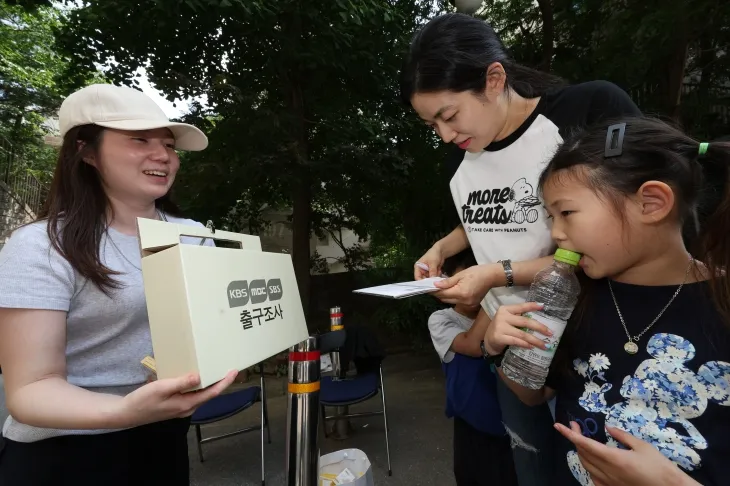 서울 성동구 금호두산아파트에 마련된 투표소 앞에서 방송사 출구조사원이 투표를 마친 유권자를 상대로 출구조사를 하고 있다. 연합뉴스
