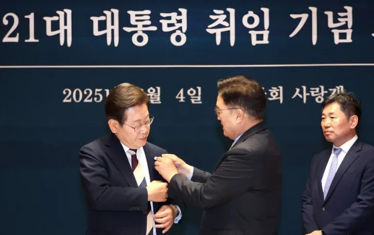 우원식 국회의장이 6월 4일 서울 국회 사랑재에서 열린 제21대 대통령 취임 기념 오찬에서 이재명 대통령에게 ‘진관사 태극기’를 달아주고 있다. 우원식 국회의장 페이스북