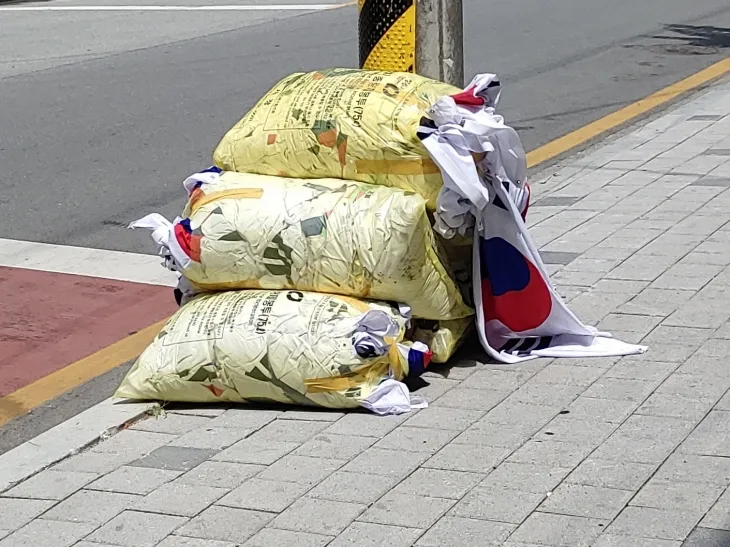 현충일인 6일 충북 청주의 한 도로변에 다량의 태극기가 담긴 쓰레기 종량제 봉투 더미가 발견돼 경찰이 조사에 나섰다. 경찰 등에 따르면 이날 오후 청주시 청원구 내덕동 청주농고 인근에서 한 주민이 이같은 현장을 발견, 지자체 민원 접수처와 경찰에 신고했다. 2025.6.6. 연합뉴스