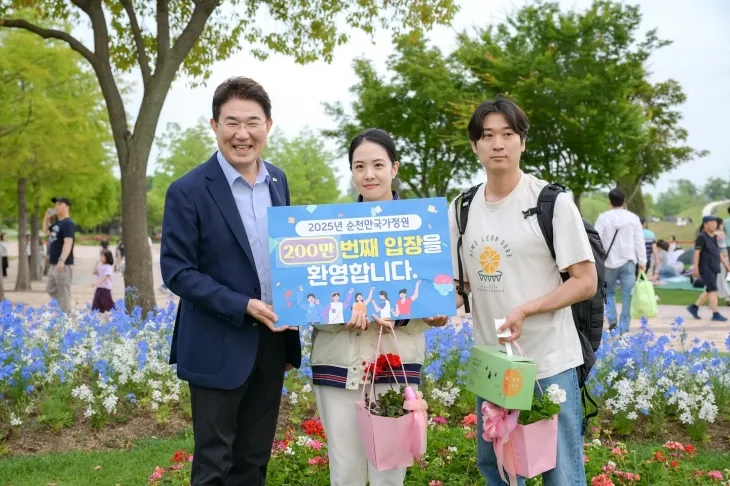 노관규 시장이 서울에서 방문한 200만번째 관람객 부부와 함께 기념 사진을 찍고 있다.