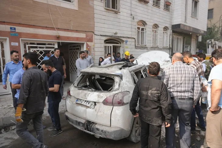 13(현지시간) 이란 테헤란에서 이스라엘의 공습으로 파손된 차량을 사람들이 점검하고 있다. 2025.6.13 신화 연합뉴스