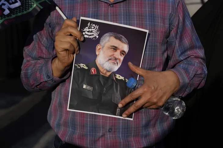 14일(현지시간) 이란 테헤란에서 한 남성이 전날 이스라엘의 공습으로 사망한 이란 혁명수비대 항공우주사단 사령관 아미르 알리 하지자데 장군의 사진을 들고 있다. 2025.6.15. AP 뉴시스