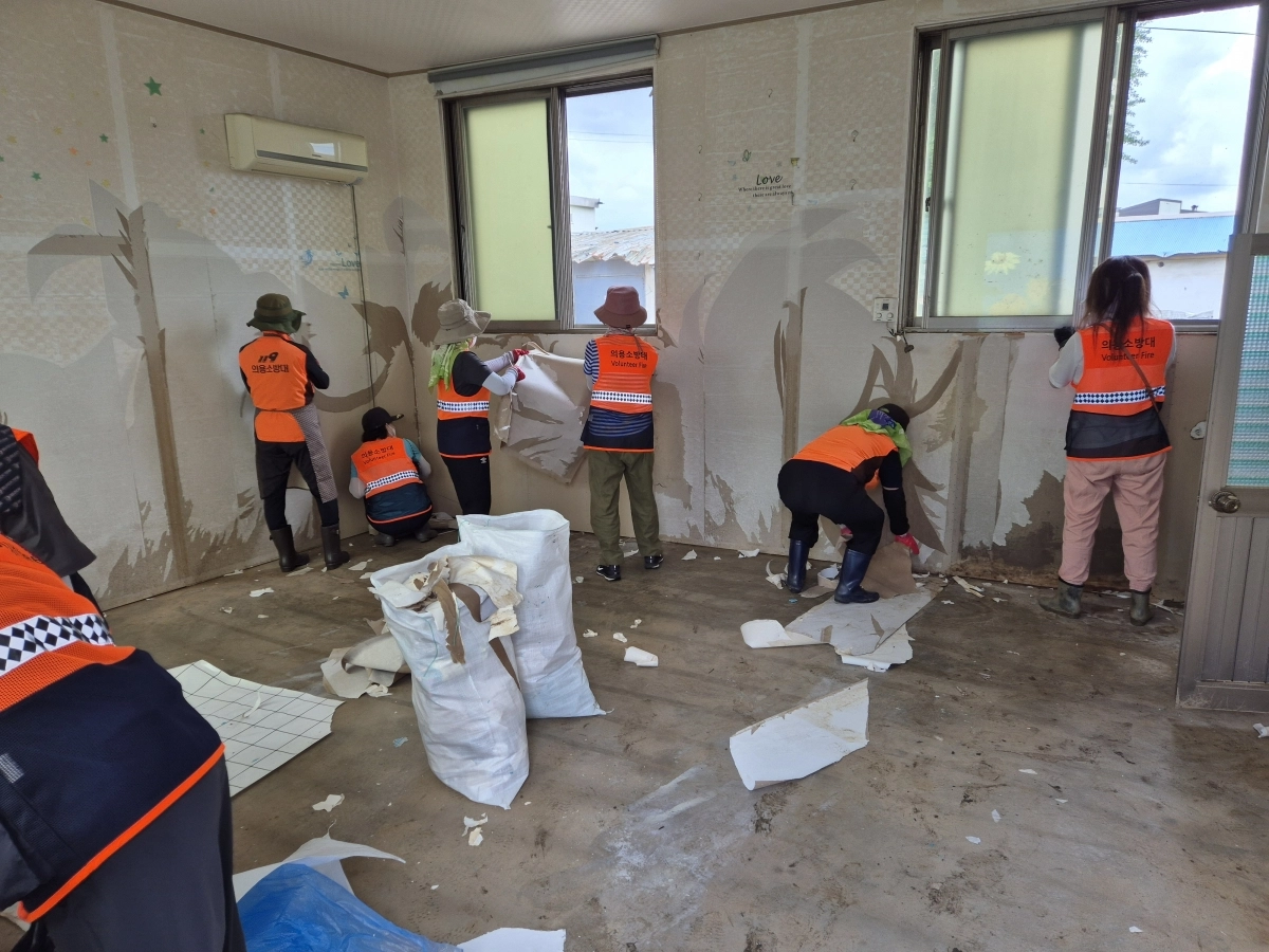 지난 21일 충남 아산 염치읍 곡교1리 일원에서 의용소방대가 빗물에 젖은 벽지 제거 작업을 하고 있다. 김우진 기자