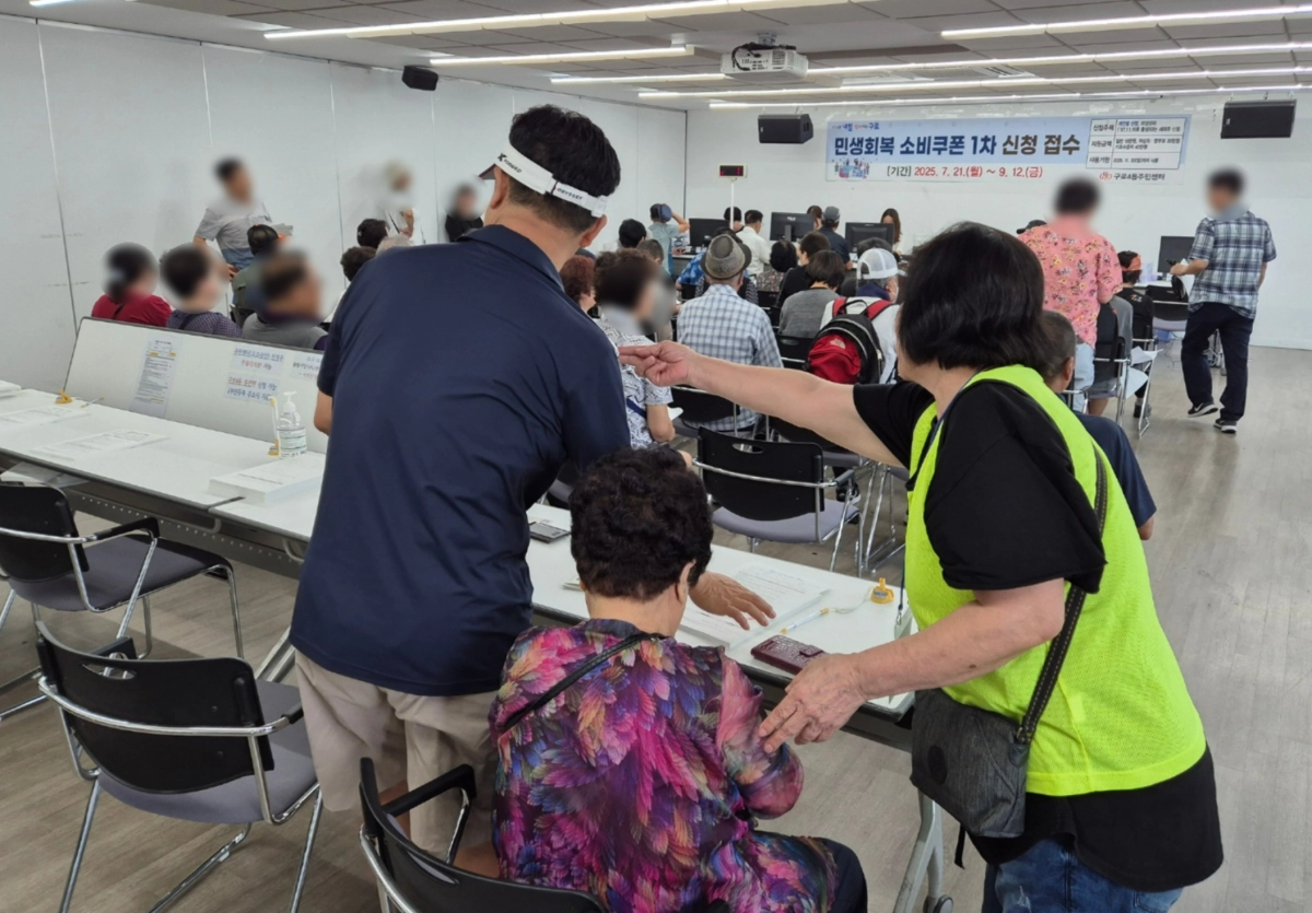 서울 구로구 자원봉사자가 구로4동 주민센터의 민생회복 소비쿠폰 지급 전담 창구에서 어르신을 안내하고 있다.   구로구 제공