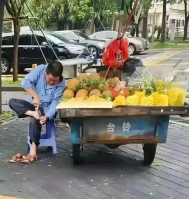 중국의 한 길거리에서 파인애플을 파는 남성이 파인애플을 써는 칼로 발 껍질을 벗기는 모습이 포착됐다. 웨이보 캡처