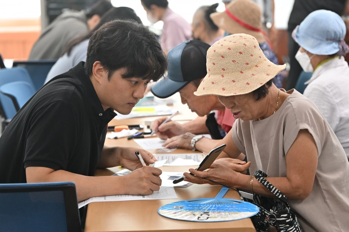 민생회복 소비쿠폰 1차 신청이 시작된 지난 21일 오전 광주 북구 두암3동 행정복지센터에서 주민들이 선불카드 신청 상담을 하고 있다. 뉴시스