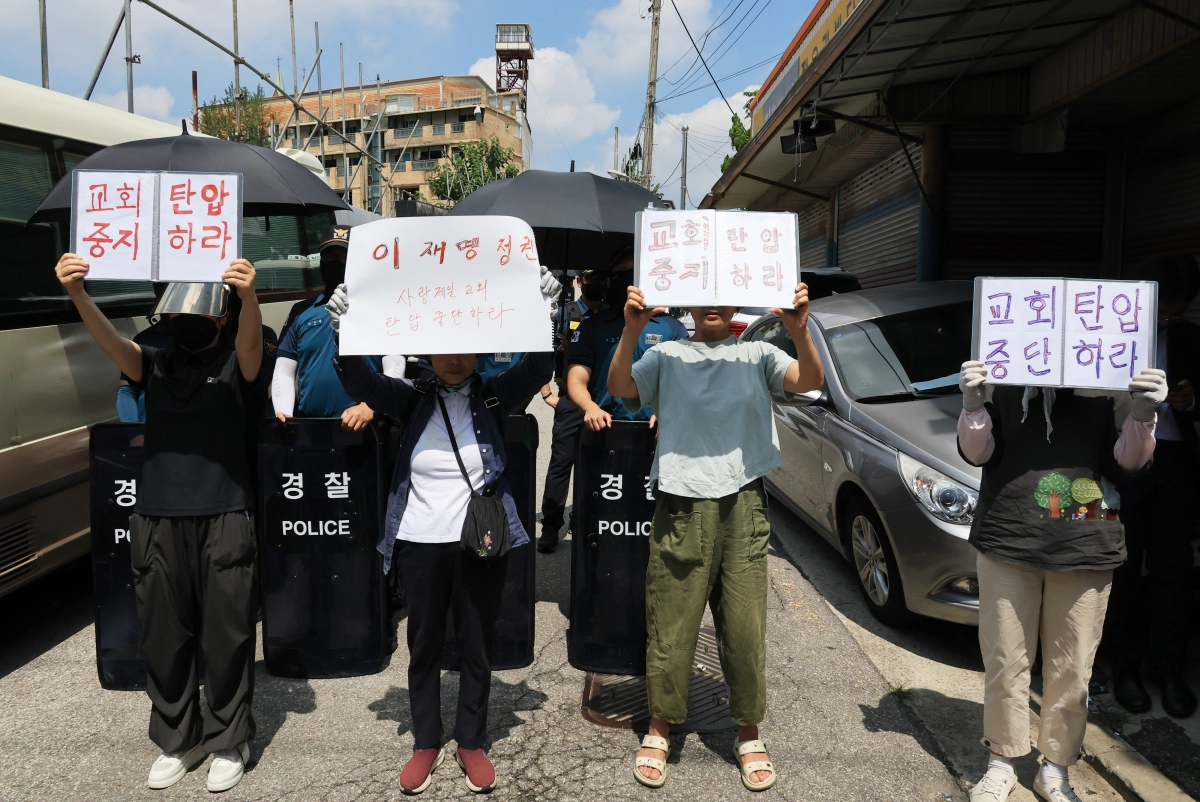 5일 오후 서울 성북구 사랑제일교회 앞에서 신도 등이 ‘교회 탄압 중단하라’고 적힌 손팻말을 들고 전광훈 목사를 압수수색한 경찰을 규탄하고 있다. 연합뉴스