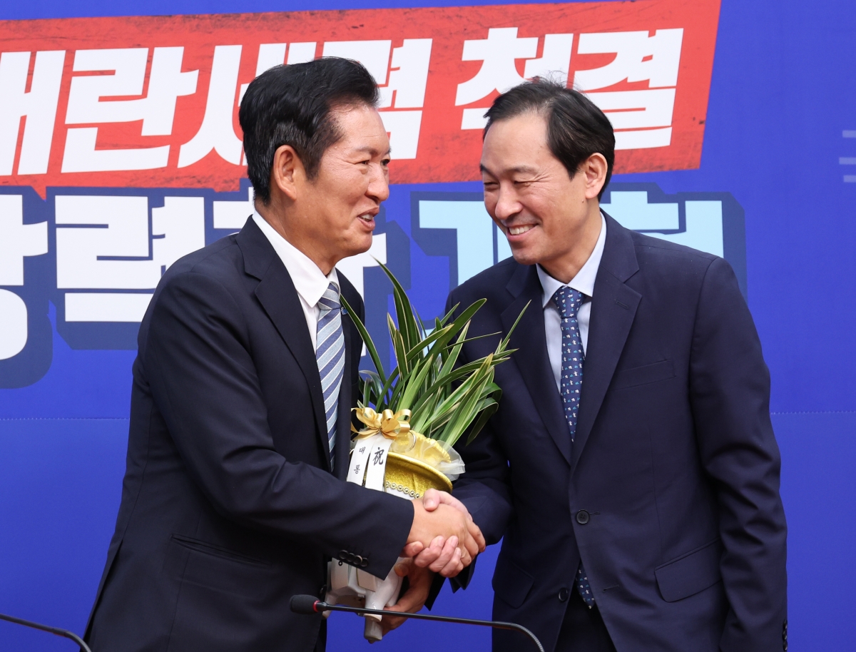 우상호(오른쪽) 정무수석이 4일 오후 서울 여의도 국회에서 정청래 더불어민주당 당대표에게 대통령이 보낸 당대표 취임 축하난을 전달하고 있다. 뉴시스