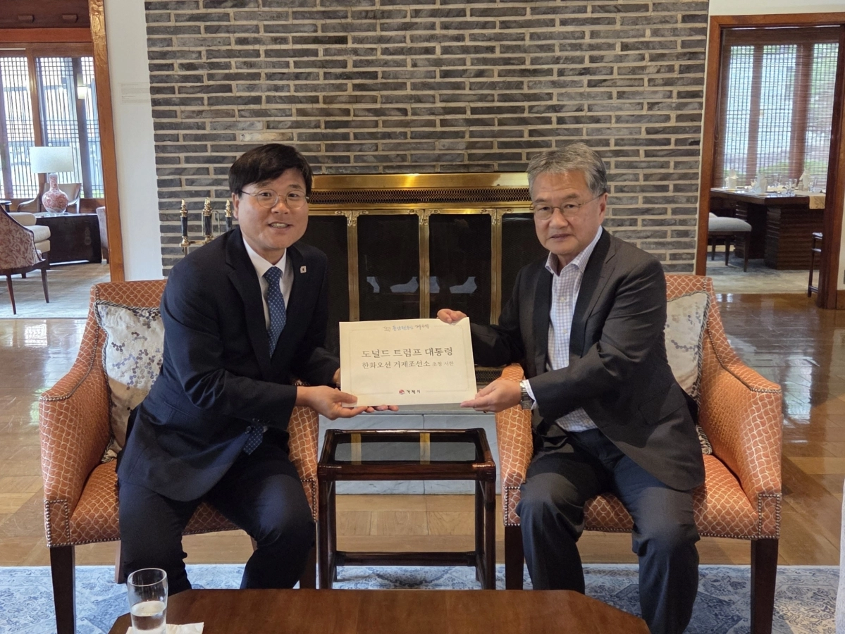 변관용(왼쪽) 거제시장이 조셉 윤 주한미국대사대리에게 ‘트럼프 미국 대통령의 한화오션 거제사업장 초청 서한’을 전달하고 있다. 2025.8.27. 거제시 제공