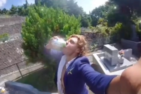 일본을 방문한 호주 관광객이 현지 묘지에 함부로 들어가 제물로 바친 술을 마시는 등 엽기 행각을 벌여 논란이 되고 있다. 사진은 호주 관광객이 일본의 한 묘 앞에 놓인 술을 따 마시는 모습. 엑스(X) 캡처