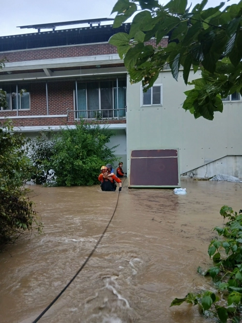 전주시 완산구 한 주택이 1층 높이까지 물이 차올라 2층에 갇혀있던 주민들이 소방대원에 의해 구조되고 있다. 전북소방본부 제공