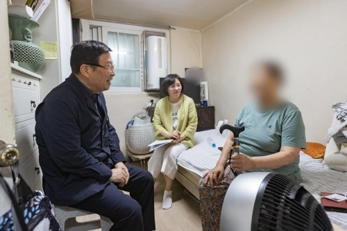 김경호(왼쪽) 서울 광진구청장이 통합돌봄 지원 시범 사업 대상자 자택에서 대화하고 있다.   광진구 제공