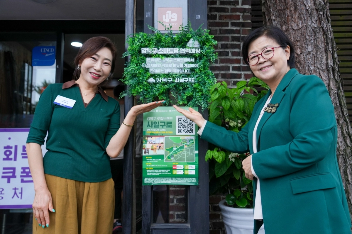 이순희 서울 강북구청장(오른쪽)이 지난 12일 스마트팜 협력매장 현판식에서 크을농 서애숙 대표와 기념사진을 찍고 있다. 강북구 제공