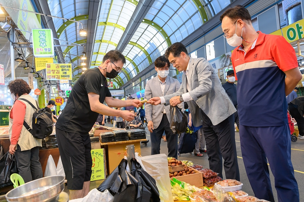 지난 추석 명절에 관내 전통시장에서 물건을 구매하고 있는 이기재 양천구청장. 양천구 제공