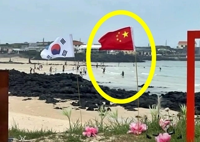 스레드 이용자에 따르면 우도 해안도로변에서 나란히 꽂힌 오성홍기와 태극기가 포착됐다. 2025.7.10 스레드