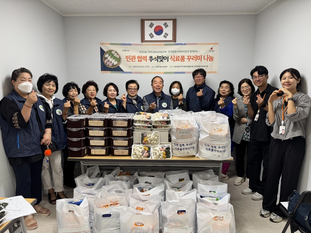 서울 성북구 장위2동 주민센터가 지난 24일 지역 단체들과 함께 저소득 40가구에 식료품 꾸러미 전달한 가운데 관계자들이 기념 촬영을 하고 있다. 성북구 제공