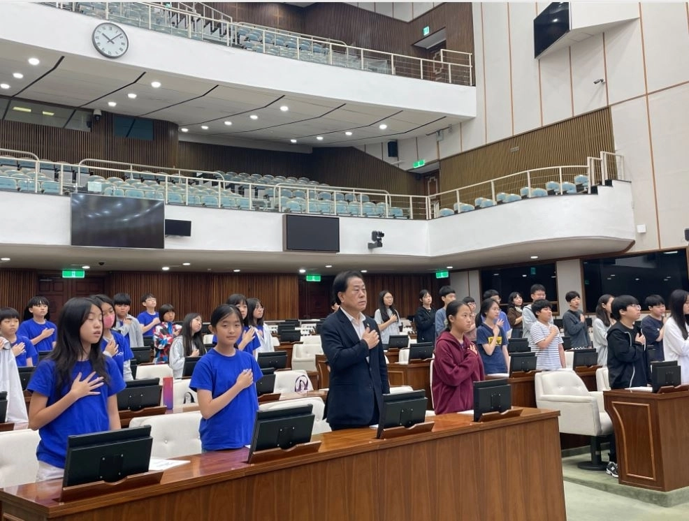 지난 29일 서울시의회 본관 본회의장에서 열린 ‘찾아오는 청소년 의회아카데미’에 참석한 김용호 시의원이 청소년 의원들과 함께 국민의례를 하고 있는 모습이다.
