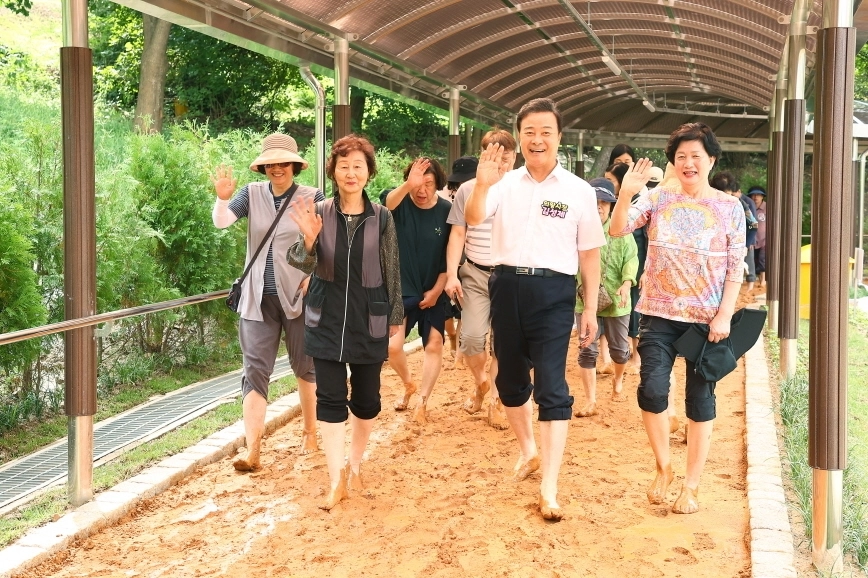 김성제 의왕시장과 시민들이 29일 개장한 ‘장안마을 황톳길’을 걷고 있다. (의왕시 제공)