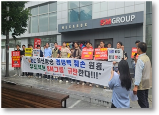 울산방송 직원 1~2명과 회사와 무관한 30여명이 SM그룹 신촌사옥 앞에서 시위를 하고 있다.