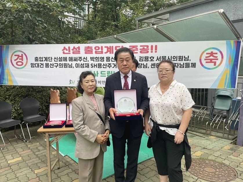 지난 9월 30일 용산구에 위치한 도원삼성아파트에서 열린 보행계단 완공식에 참석한 김용호 의원이 아파트 주민들로부터 감사패를 수여받고 기념촬영을 하고 있다.